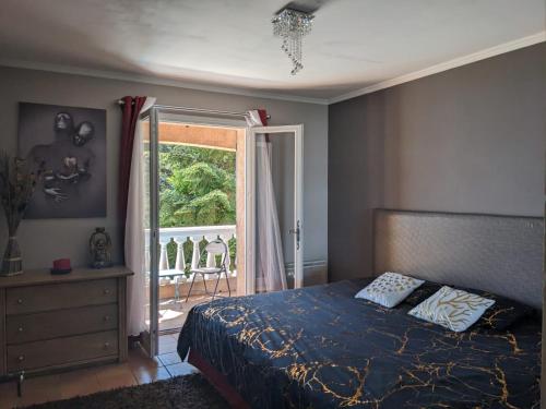 une chambre avec un lit et une porte coulissante en verre dans l'établissement Magnifique villa vue mer avec jacuzzi, à La Turbie