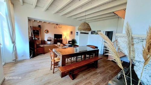 una sala da pranzo con tavolo e sedie e un soggiorno di Domaine de Cachaou Villa Leyr'ial sauna & spa a Salles