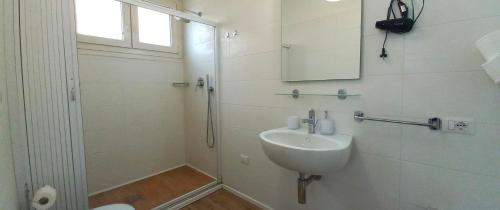 biała łazienka z umywalką i prysznicem w obiekcie B&B Leo w Cagliari
