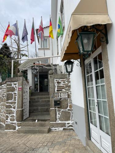 una entrada a un edificio con banderas. en Solar S.Bento, en Santo Tirso