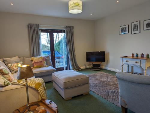 a living room with a couch and a tv at Little Chilsbury in Potterne