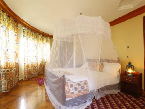 a bedroom with a bed with a canopy at Top of the World Lodges Fort Portal in Fort Portal