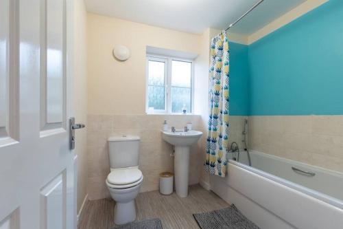 uma casa de banho com um WC e um lavatório em 3-Bedroom Home in Peterborough with Free Parking & Netflix by HP Accommodation em Peterborough