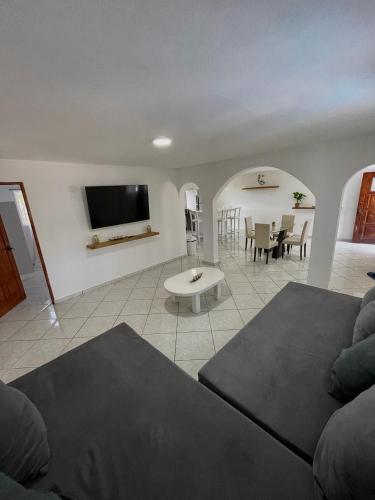 a living room with a couch and a tv at HUMMINGBIRD CABARETE in Cabarete