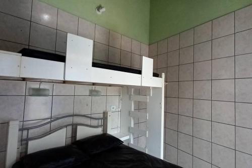 a room with white shelves on a tiled wall at Bertioga Praia Guaratuba - Condomínio Costa do Sol in Bertioga