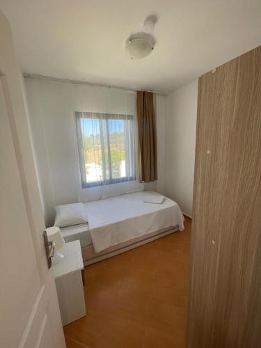 a small bedroom with a bed and a window at PLEASENT SUNSET in CESME-SITE SOLEY 17 in Çeşme