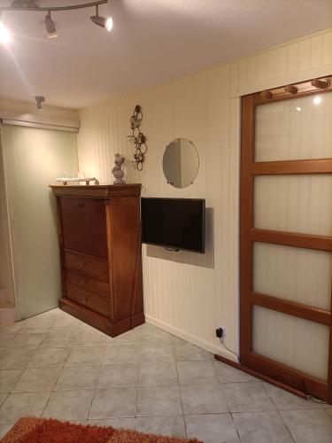 a living room with a television and a door at LE CLOS DE GRIGNON in Thiverval-Grignon