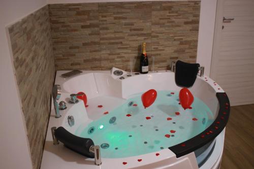 a bath tub with hearts in it with a bottle of wine at MaryGrace B&B in Castellammare di Stabia