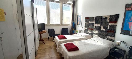 pokój hotelowy z dwoma łóżkami i telewizorem w obiekcie B&B Leo w Cagliari