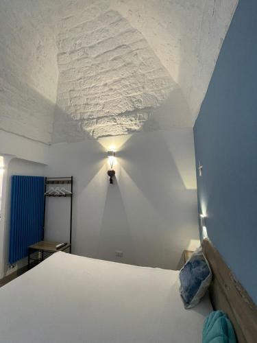 ein Schlafzimmer mit einem weißen Bett und einer Decke in der Unterkunft L'Ostrica in Ostuni