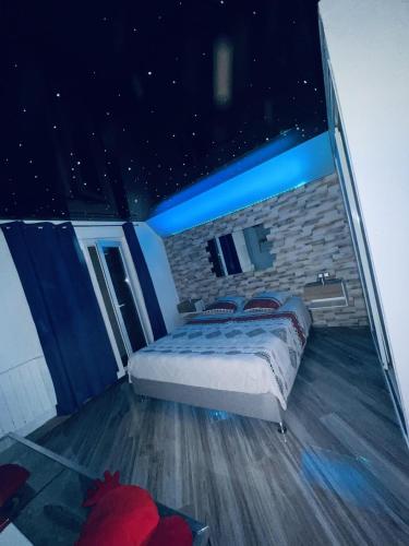 - une chambre avec un lit dans une pièce dotée d'étoiles au plafond dans l'établissement Appartement Romantique L'Escapade Jacuzzi, à Espondeilhan
