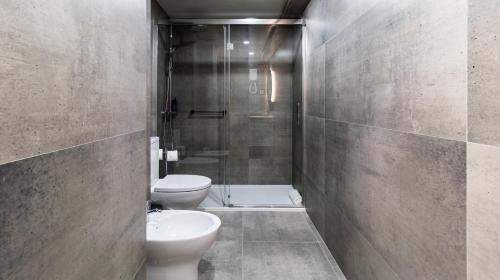 a bathroom with a shower and a toilet and a sink at Albergaria Quim Barreiros in Vila Praia de Âncora
