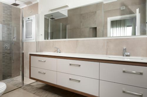 ein Badezimmer mit zwei Waschbecken und einer Glasdusche in der Unterkunft Villa 26 - 7 bedrooms with private pool in Eilat