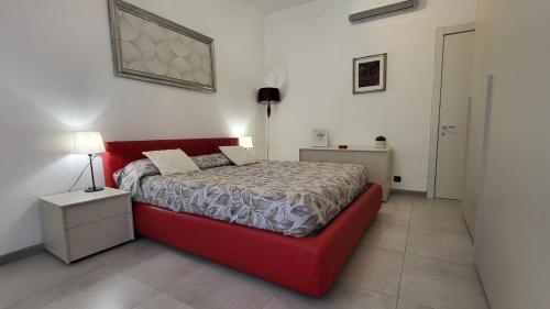 una camera bianca con letto rosso di Bilocale Manuela in via Signorelli a Garbagnate Milanese a Garbagnate Milanese