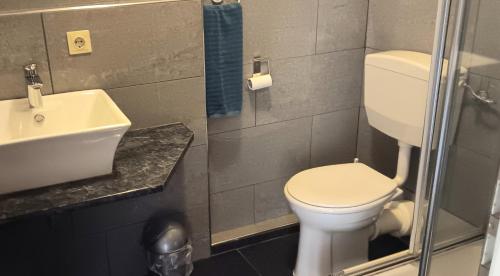 a bathroom with a white toilet and a sink at Zimmer zentral in Berlin in Berlin