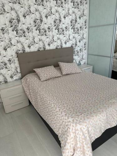 a bedroom with a bed with a floral wall at Luksus i Alicante in Alicante