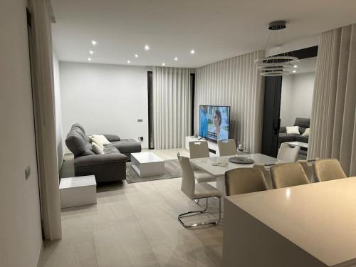 a living room with a couch and a table and chairs at Luksus i Alicante in Alicante