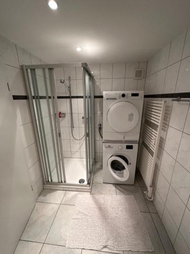 La salle de bains est pourvue d'une douche et d'un lave-linge. dans l'établissement Ferienwohnung Arvenbüel Bergtraum über Amden, à Amden