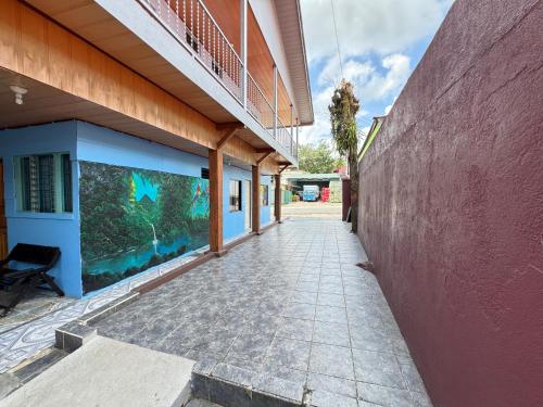 an empty walkway next to a building with an aquarium at Cabinas Las Palmas del Sol in Fortuna
