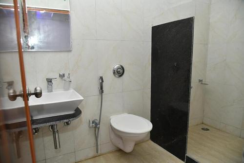 a bathroom with a toilet and a sink at Hotel Sea Rock Porte Blair in Port Blair