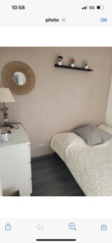 une chambre avec un lit et un miroir au mur dans l'établissement Appartement mer, à La Grande Motte