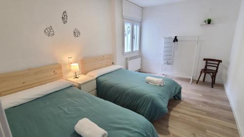 two beds in a room with green sheets at Casa renovada con chill out en Espinosa in Espinosa de los Monteros