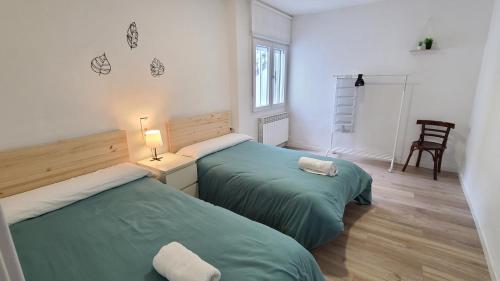 2 letti in una camera con lenzuola verdi di Casa renovada con chill out en Espinosa a Espinosa de los Monteros