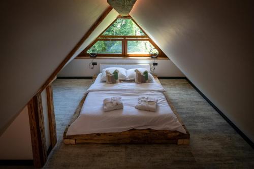 een slaapkamer op zolder met een bed en een raam bij Uroczysko in Lesko