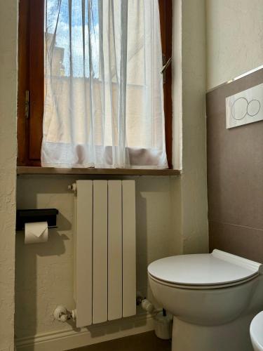 a bathroom with a toilet and a window at Camere di Bianca in Foligno