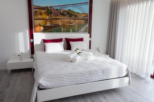 ein Schlafzimmer mit einem weißen Bett mit zwei ausgestopften Tieren in der Unterkunft Quinta Carolina in Póvoa de Lanhoso