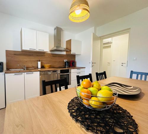 a kitchen with a bowl of fruit on a table at Apartma Jana in Žirovnica