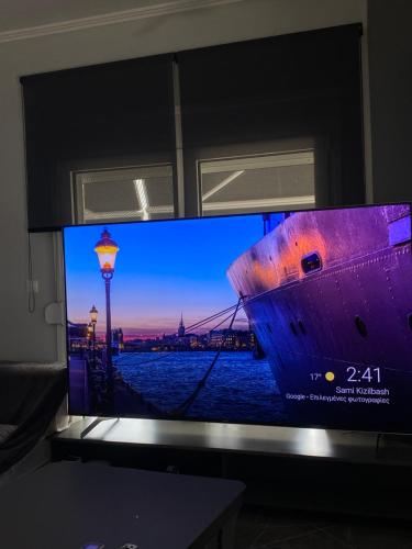 uma televisão de ecrã plano com uma fotografia de um navio em Sountou home em Xanthi