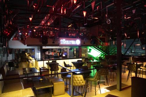 a restaurant with a bar with tables and chairs at Vertigo Hotel in Lagos