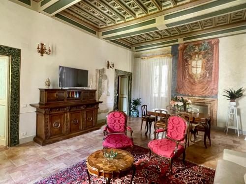 a living room with red chairs and a table at Palazzo Lauri Spoleto in Spoleto