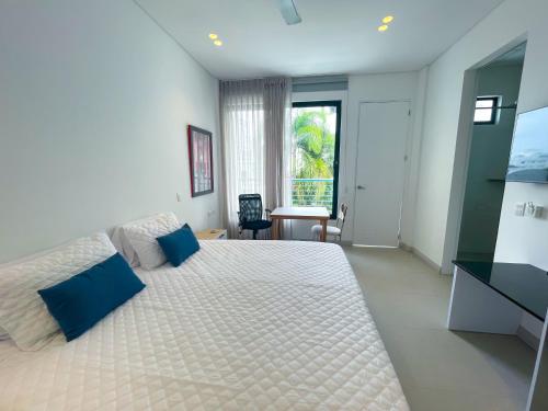um quarto com uma cama grande e almofadas azuis em Apartaestudio Brumilo 3 em Montería