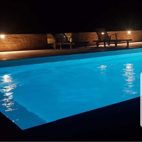 a swimming pool at night with blue illumination at La spacieuse maison des miots in Hiersac