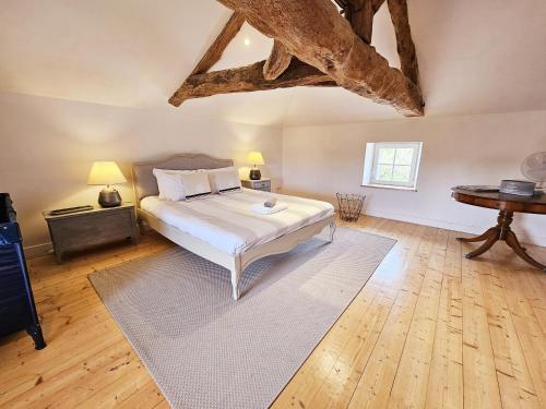a bedroom with a bed and a wooden floor at La spacieuse maison des miots in Hiersac