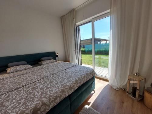 a bedroom with a bed and a large window at Apartmán Business Comfort se zahradou in Hradec Králové