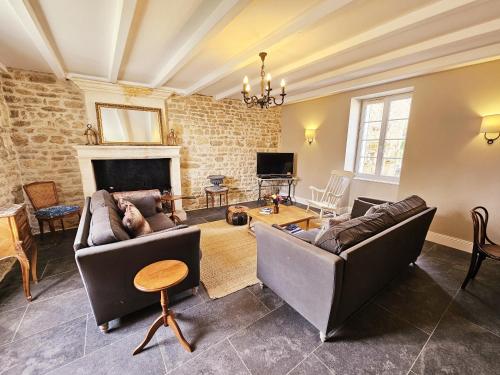 a living room with two couches and a fireplace at La spacieuse maison des miots in Hiersac