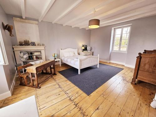 a living room with a bed and a table at La spacieuse maison des miots in Hiersac