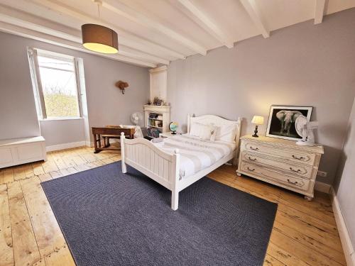 a bedroom with a bed and a tv on a dresser at La spacieuse maison des miots in Hiersac