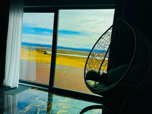 a chair sitting in a room looking out a window at Luxury villa with breathtaking view & hot tub, middle of Golden Circle , Smart home lights & electronics for comfort in Reykholt