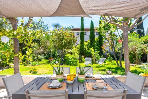 an outdoor table with chairs and an umbrella at Maison Cap Brun Jardin Parking in Toulon