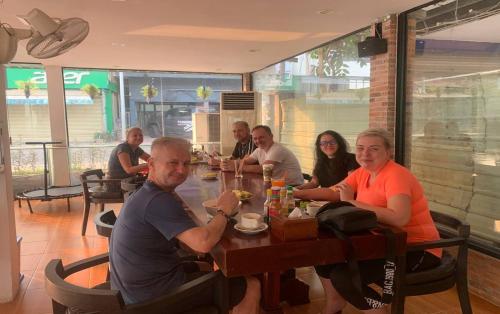a group of people sitting at a table in a restaurant at Blossoming Romduol Boutique in Siem Reap