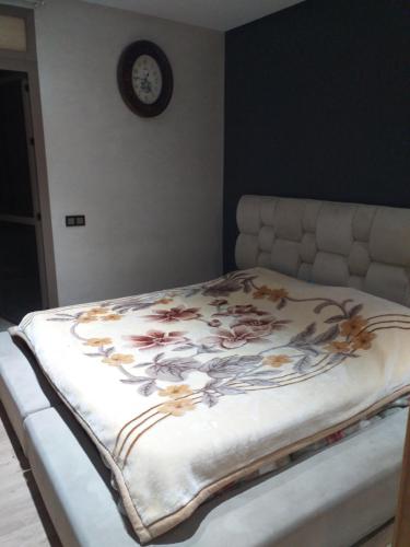 Una cama con una manta floral en un dormitorio en الدار البيضاء بوركون, en Aïn Harrouda