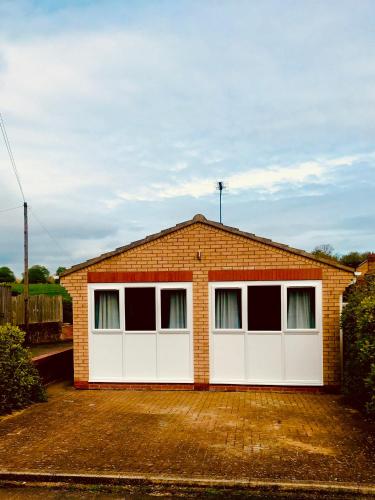 a brick house with a white garage at The Chalet in Beverley