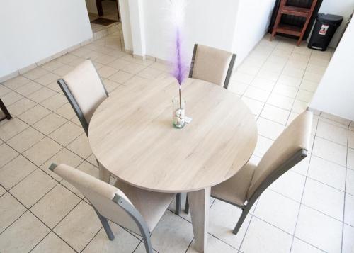 a wooden table with chairs and a vase with purple flowers at Casa Roma in Calvillo