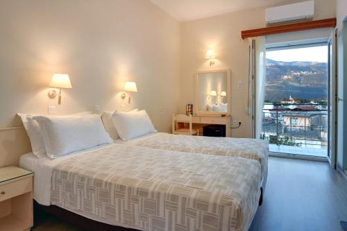 a hotel room with a bed and a large window at Palladion Hotel in Ioannina