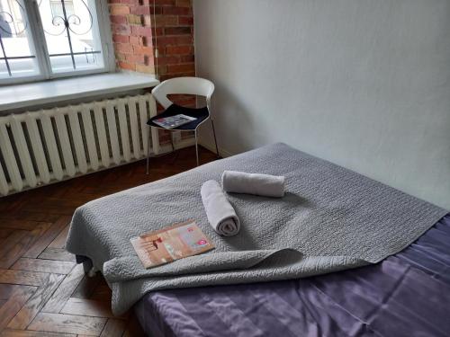 1 dormitorio con 1 cama con toallas y silla en Old Town Charm TLN en Tallin