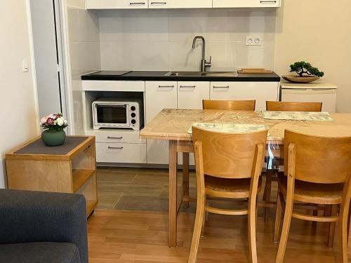 a kitchen with a table and chairs and a sink at Studio rénové avril 2024 wifi et parking in Le Port-Marly